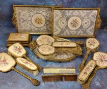 A mid 20th century gilt metal dressing table set, the backs embroidered with bouquet of flowers, c.