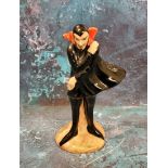 A Carlton Ware Mephisto Series figure, he stands, wearing a black cape, 11cm high, printed mark