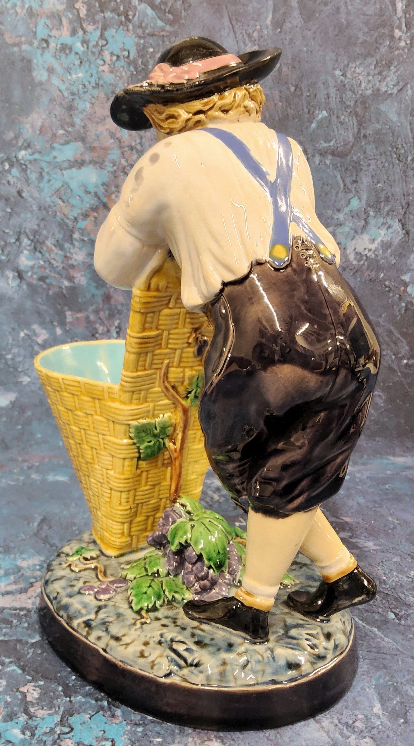 A Minton majolica figure, The Grape Picker, he stands leaning on his pannier, 24cm high, impressed - Image 4 of 7