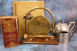 An early 20th century brass and oak table gong, 28cm wide; a  a plated half fluted teapot and