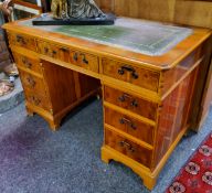 A reproduction burr yew pedestal desk, green tooled leather inlay, three drawers to frieze, each