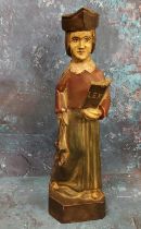 An 18th century polychrome carving, of a lawyer, standing in robes, holding a book, 30.5cm high