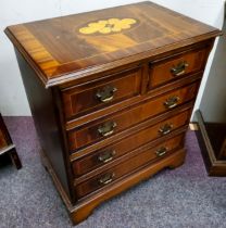 A small reproduction bachelor's chest of two over three drawers, satinwood flower head patera, brass