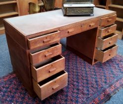 Heal's - a mid 20th century limed oak, tooled leather inlaid desk with central drawer to frieze