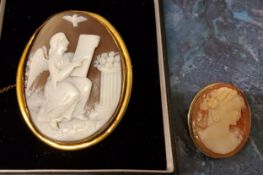A Victorian gilt metal oval cameo, caved with an angel, 6cm, c.1880;  another, smaller, 3cm (2)