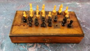 A 19th century travelling chess set and pieces, the board stained, 18cm wide, c.1890