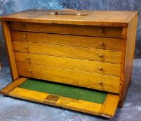 An early 20th century oak tabletop collectors cabinet, the fall fronts, enclosing five graduated