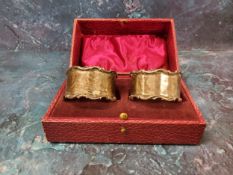 A pair of silver napkin rings, C and S scroll borders, Sheffield 1904, cased