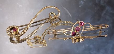 A 9ct gold bar brooch, centrally collet set with three pink round stones, flanked by two seed