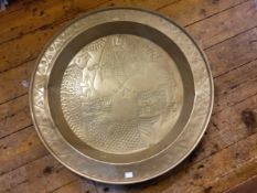 A large 19th century brass charger, inscribed with a stylised mermaid and sea animals, 73cm wide,