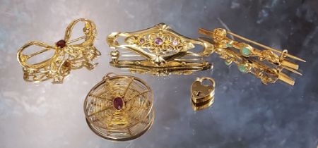 A 9ct gold shaped bar brooch, the suspended central scroll work terminating in leaves, centrally