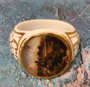 A 19th century continental napkin ring, painted with an oval panel, picked out in gilt, 6cm diam,