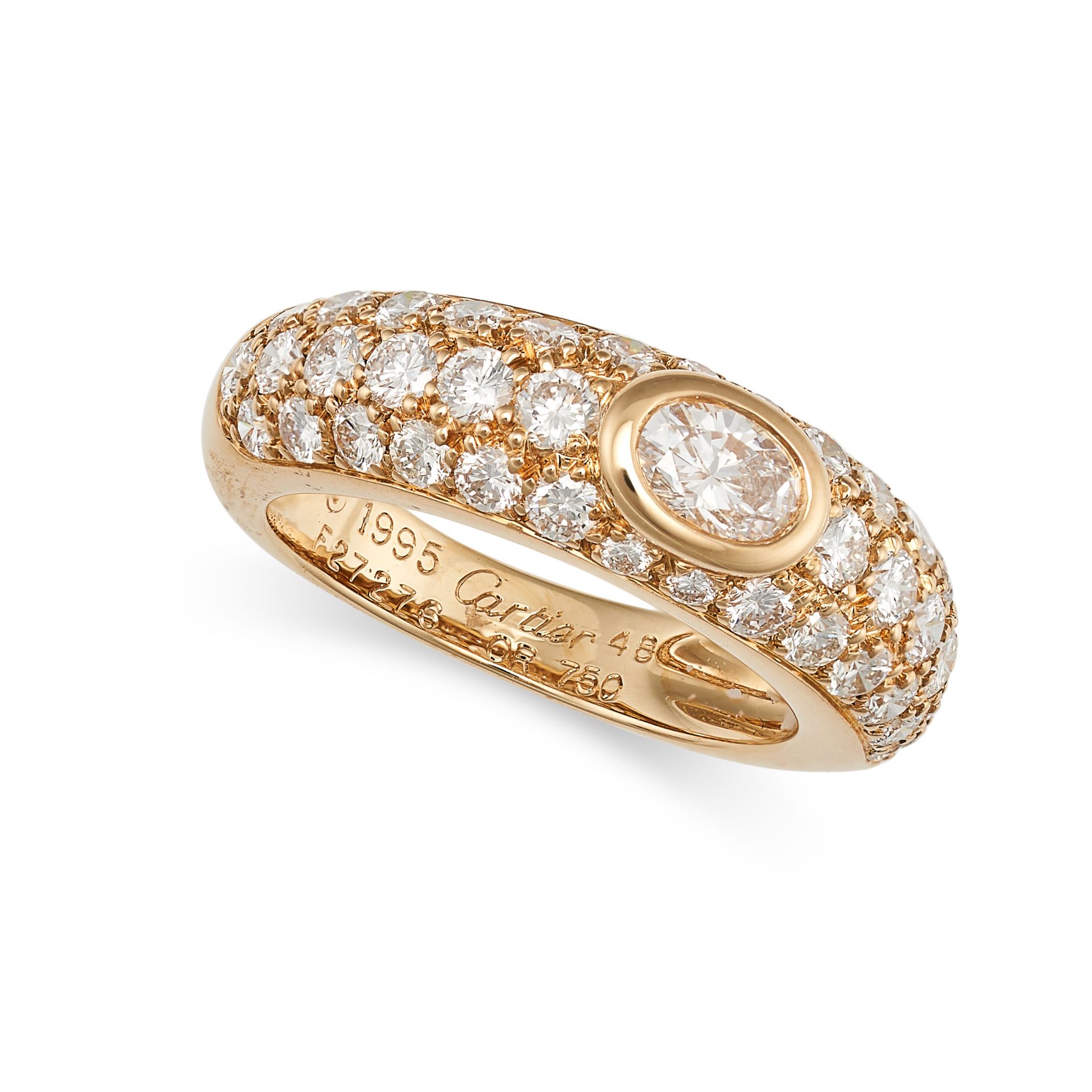 CARTIER, A DIAMOND RING in 18ct yellow gold, set with an oval cut diamond, the band accented by r...
