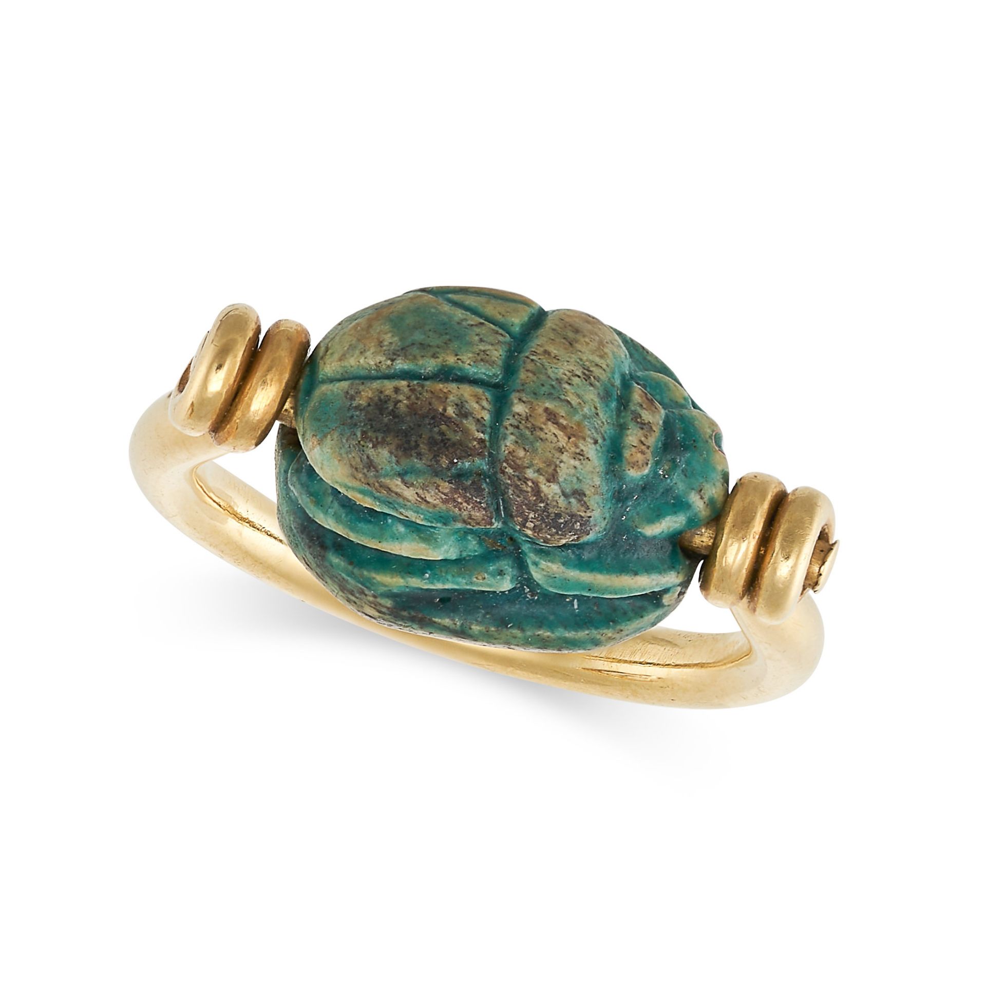 AN EGYPTIAN REVIVAL SCARAB BEETLE RING in 18ct yellow gold, set with a carved blue hardstone scar...