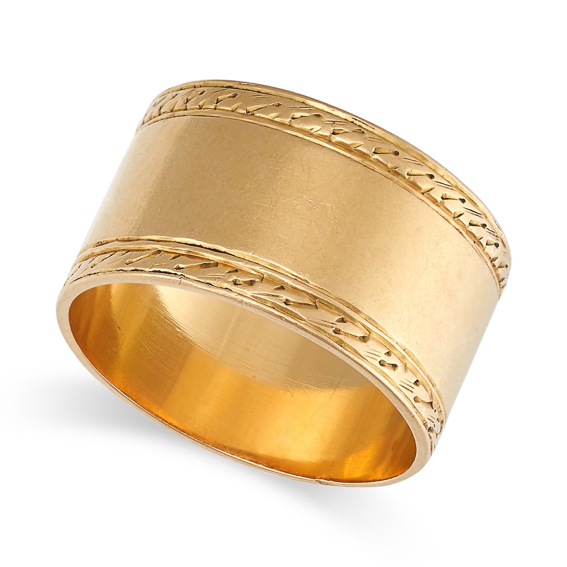 A GOLD BAND RING in yellow gold, the wide band with engraved detailing, no assay marks, size K1/2...