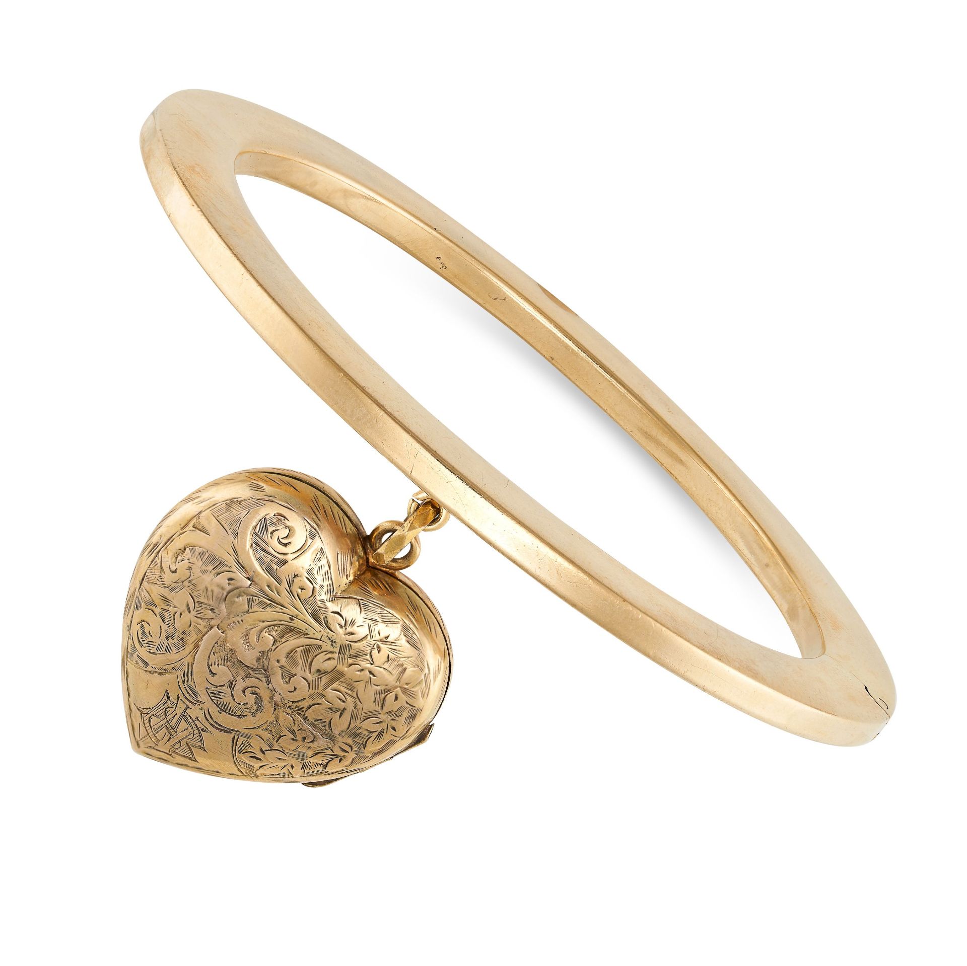 AN ANTIQUE VICTORIAN GOLD LOCKET BANGLE in yellow gold, the plain hinged bangle suspending an eng...