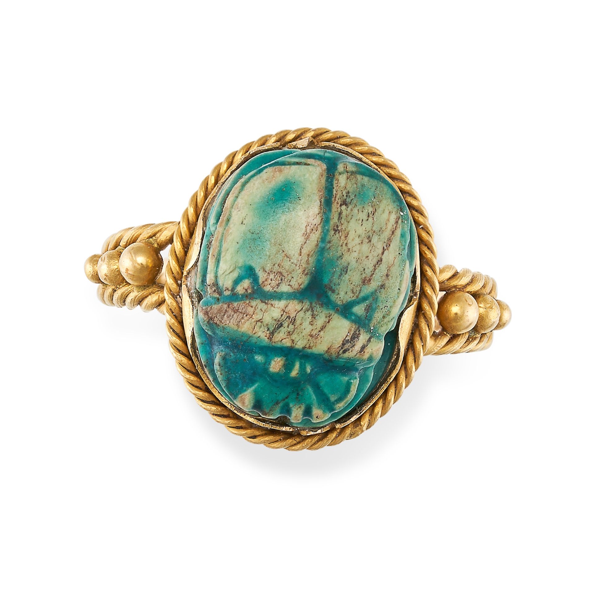 AN EGYPTIAN REVIVAL SCARAB BEETLE RING in yellow gold, set with a carved blue hardstone scarab be...