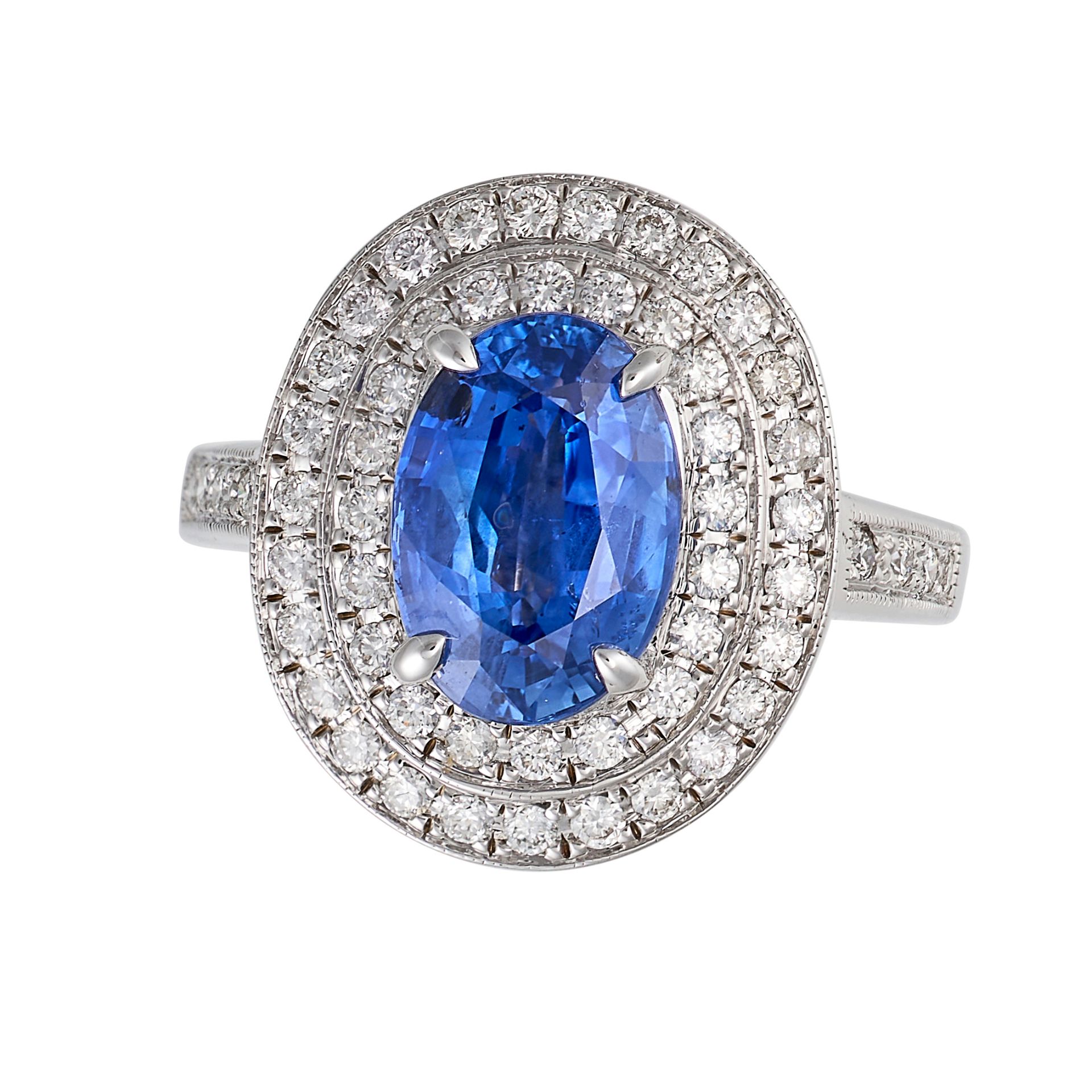 A SAPPHIRE AND DIAMOND CLUSTER RING in 18ct white gold, set with an oval cut sapphire of 2.40 car...