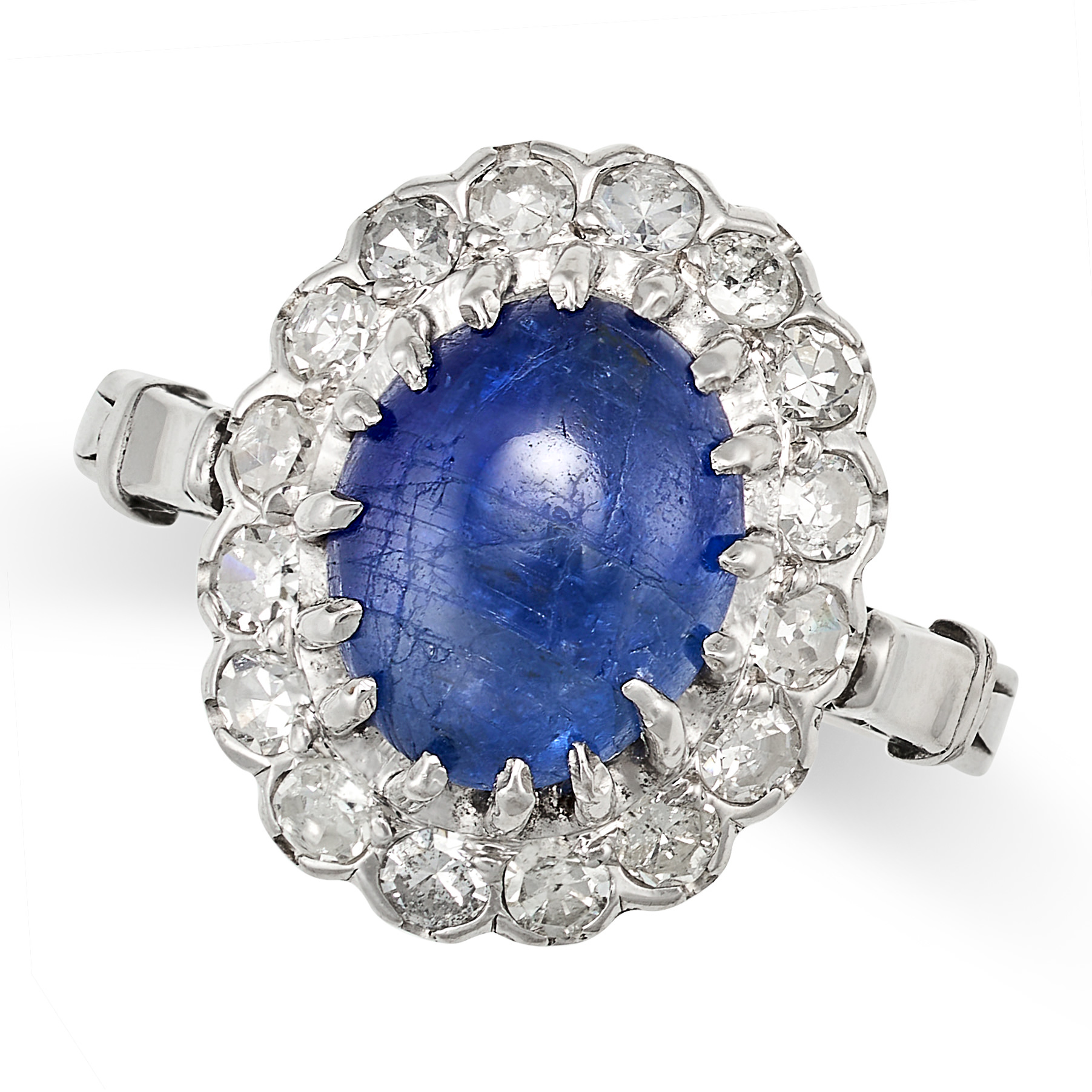 A SAPPHIRE AND DIAMOND CLUSTER RING in white gold, set with a cabochon sapphire of approximately ...
