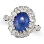 A SAPPHIRE AND DIAMOND CLUSTER RING in white gold, set with a cabochon sapphire of approximately ...