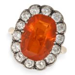 A FIRE OPAL AND DIAMOND CLUSTER RING in yellow gold and silver, set with a cushion cut fire opal ...