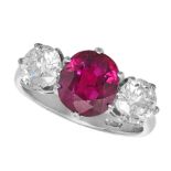 A RUBY AND DIAMOND THREE STONE RING in platinum, set with an oval cut ruby of approximately 3.24 ...