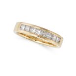 A DIAMOND BAND RING in yellow gold, channel set with a row of princess cut diamonds, indistinct a...