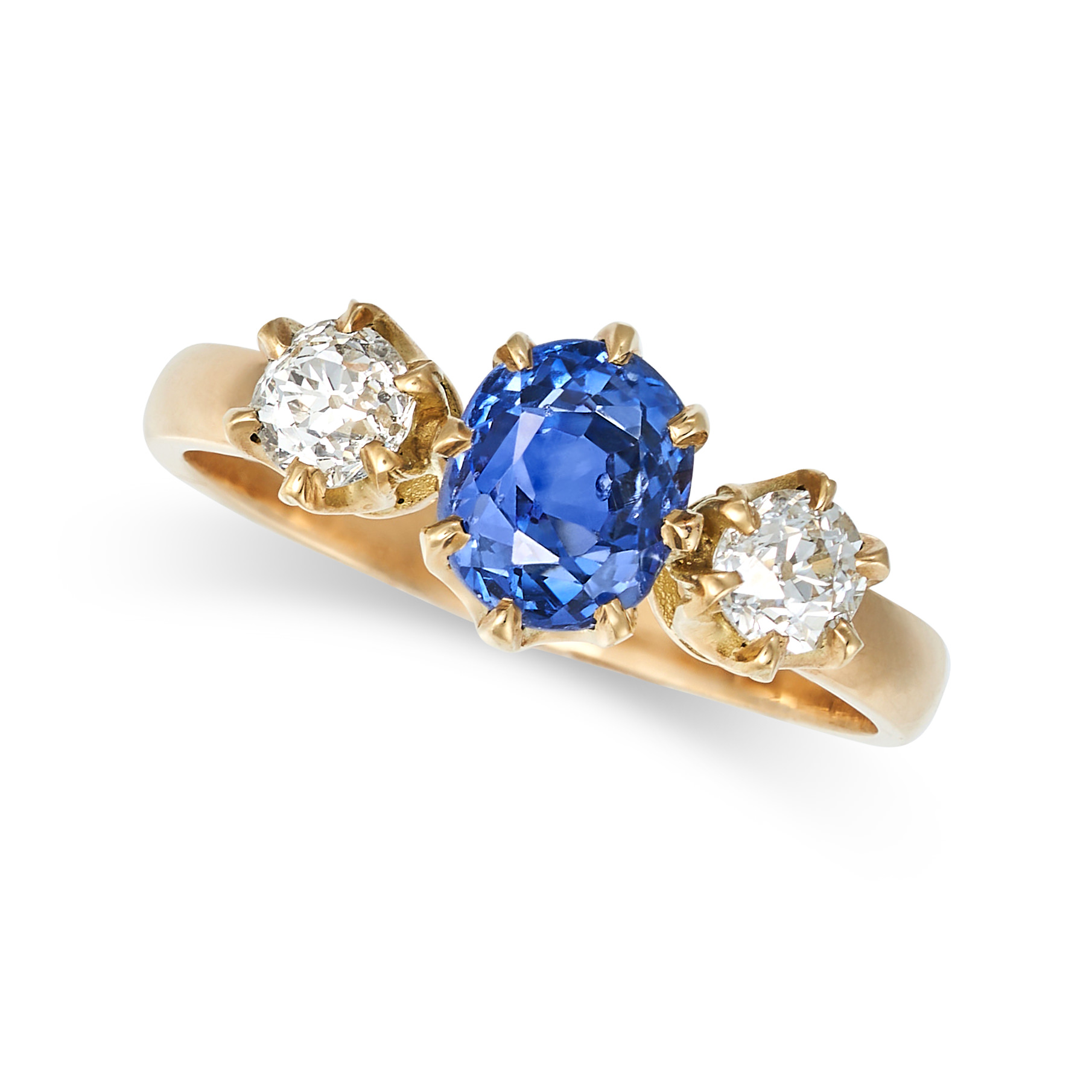 A CEYLON NO HEAT SAPPHIRE AND DIAMOND THREE STONE RING in yellow gold, set with an oval cut sapph...