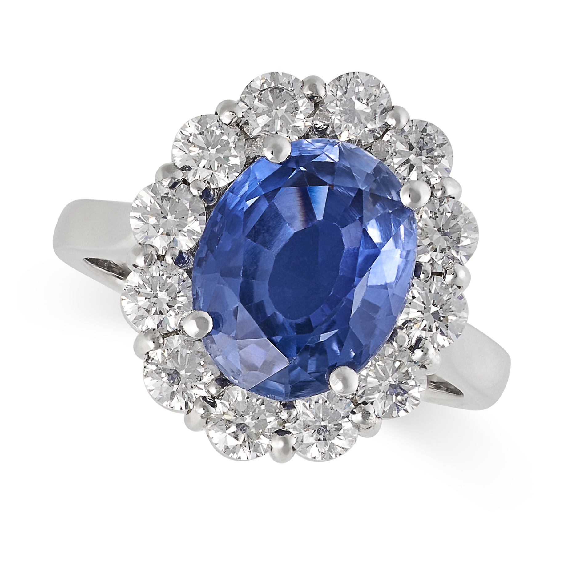 A SAPPHIRE AND DIAMOND CLUSTER RING in platinum, set with an oval cut sapphire of approximately 5...