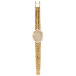 AUDEMARS PIGUET, A VINTAGE LADIES DIAMOND WRISTWATCH in 18ct yellow gold, the oval face in a clus...