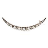 AN ANTIQUE VICTORIAN DIAMOND AND PEARL CRESCENT MOON BROOCH in yellow gold and silver, designed a...