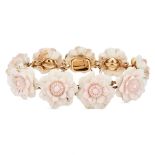 AN ANTIQUE CONCH SHELL FLOWER BRACELET in yellow gold, comprising a row of nine conch shells carv...