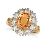 AN IMPERIAL TOPAZ AND DIAMOND CLUSTER RING in 18ct yellow gold, set with an oval cut topaz of app...