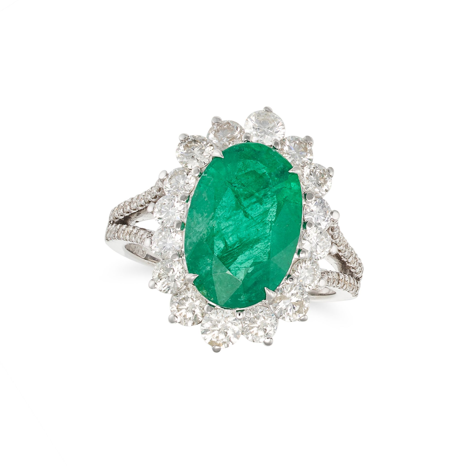 AN EMERALD AND DIAMOND CLUSTER RING in 18ct white gold, set with an oval cut emerald of 3.56 cara...