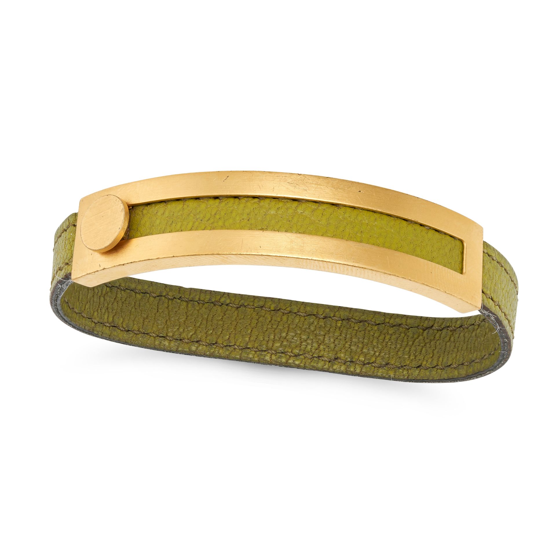 NO RESERVE - HERMES, A SLIDING BRACELET comprising a green leather strap with a sliding bronze pl...