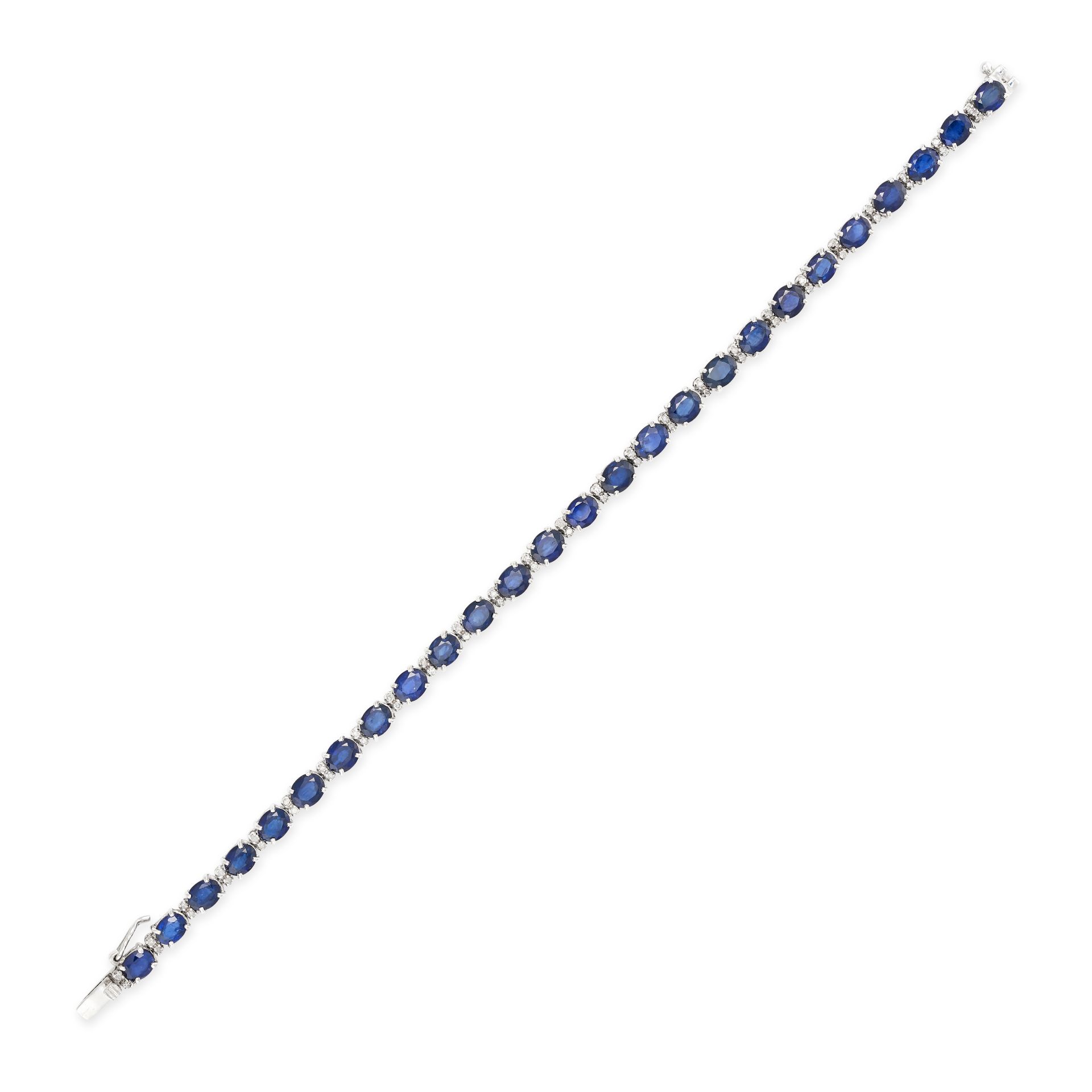 A SAPPHIRE AND DIAMOND LINE BRACELET in 18ct white gold, set with a row of oval cut sapphires acc...