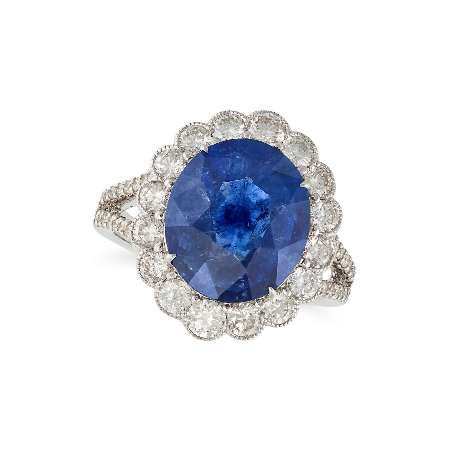 A SAPPHIRE AND DIAMOND CLUSTER RING in 18ct white gold, set with an oval cut sapphire of 7.02 car...