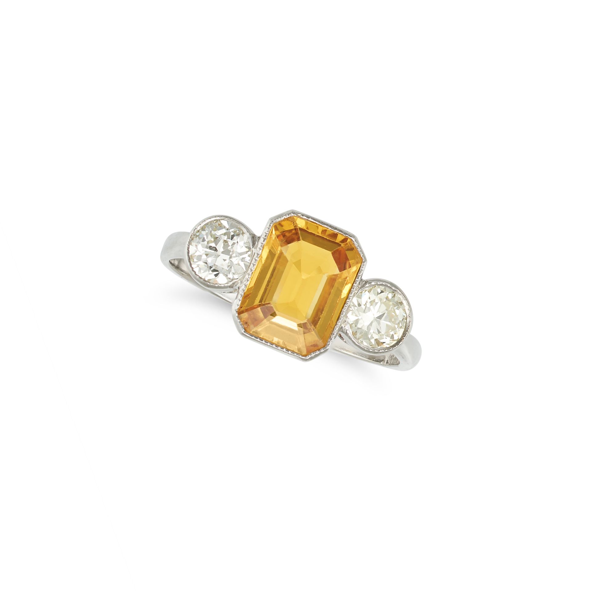 A YELLOW SAPPHIRE AND DIAMOND THREE STONE RING in platinum, set with an octagonal step cut yellow...