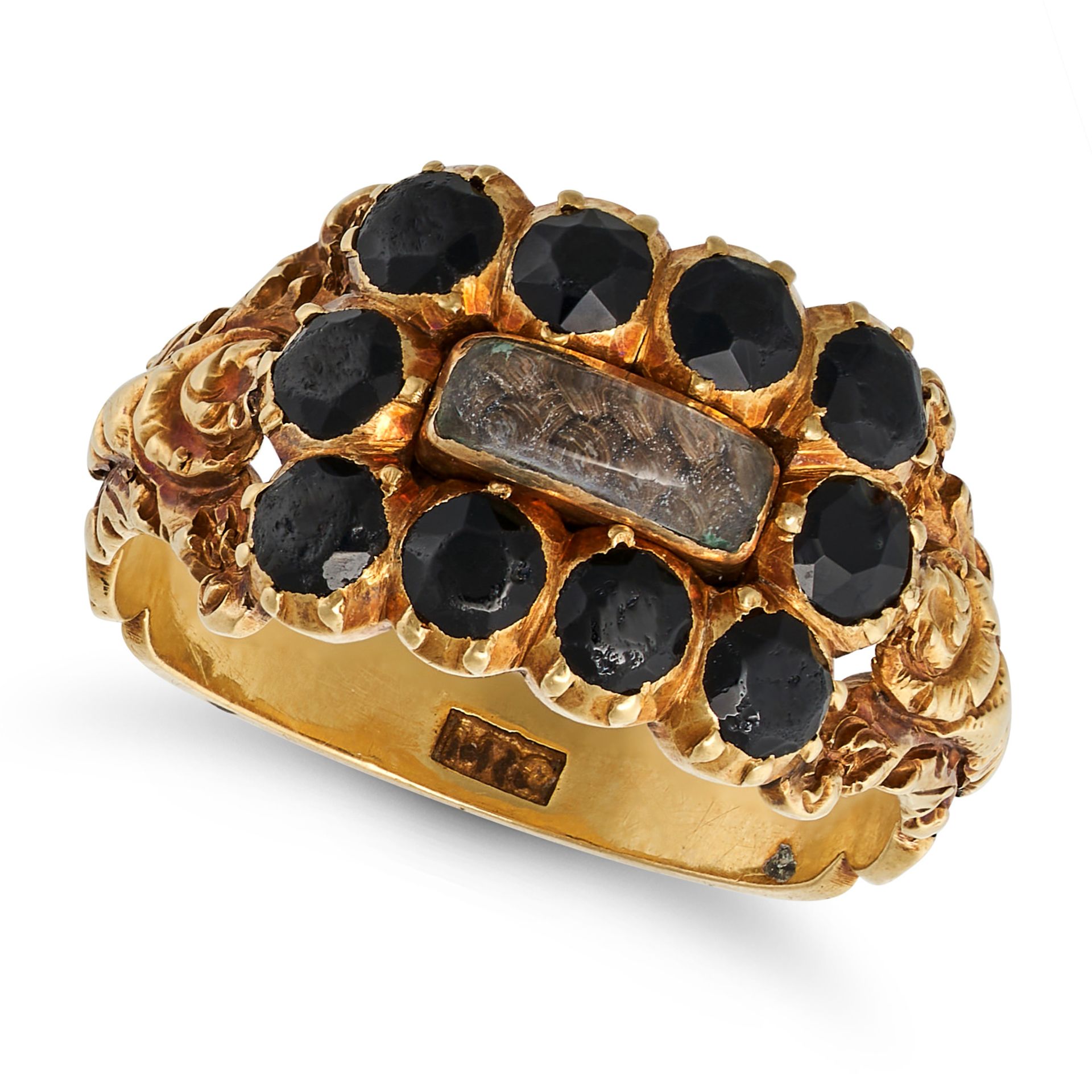 AN ANTIQUE JET MOURNING RING in yellow gold, set with a glass panel containing hairwork in a bord...