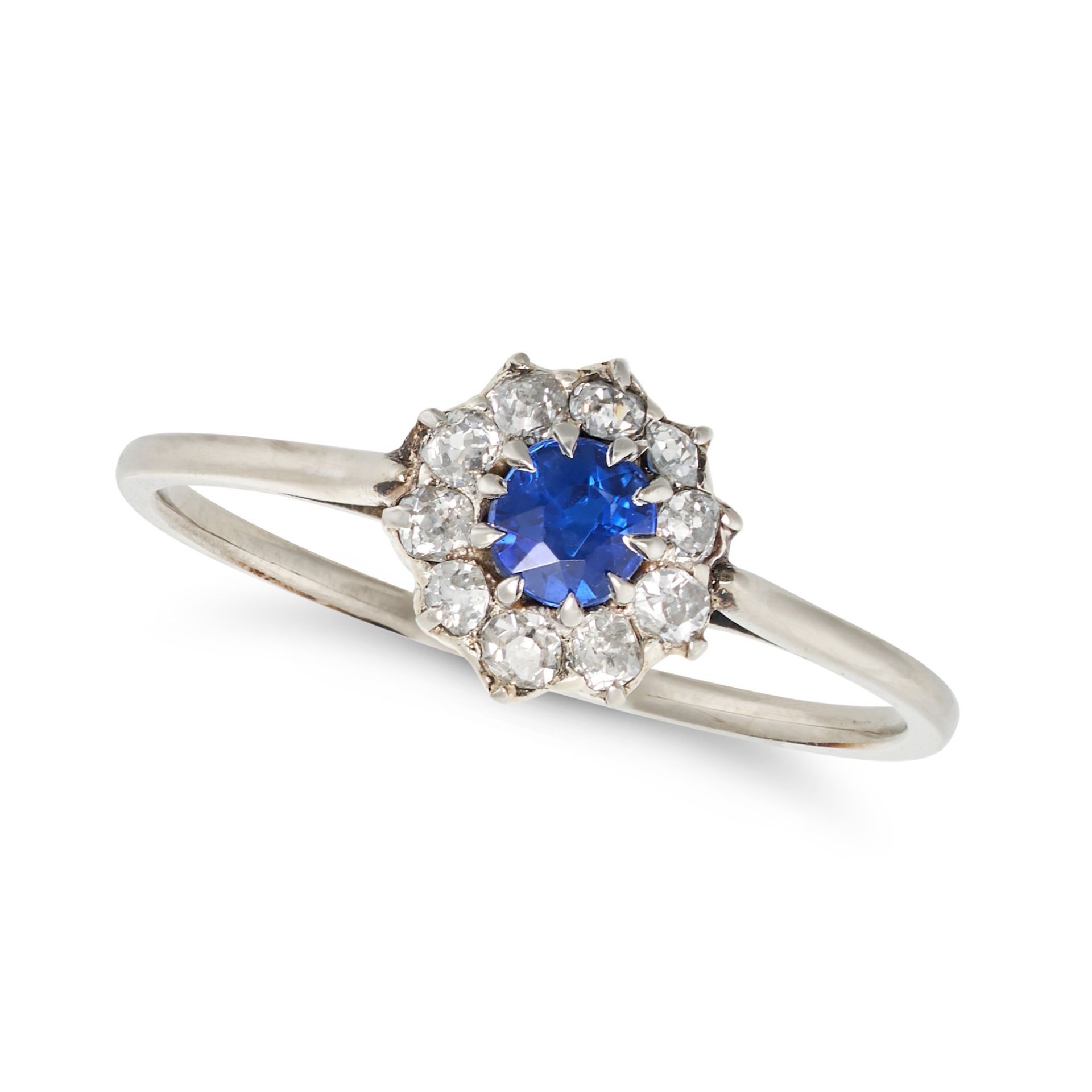 A SAPPHIRE AND DIAMOND CLUSTER RING set with a round cut sapphire in a cluster of old cut diamond...