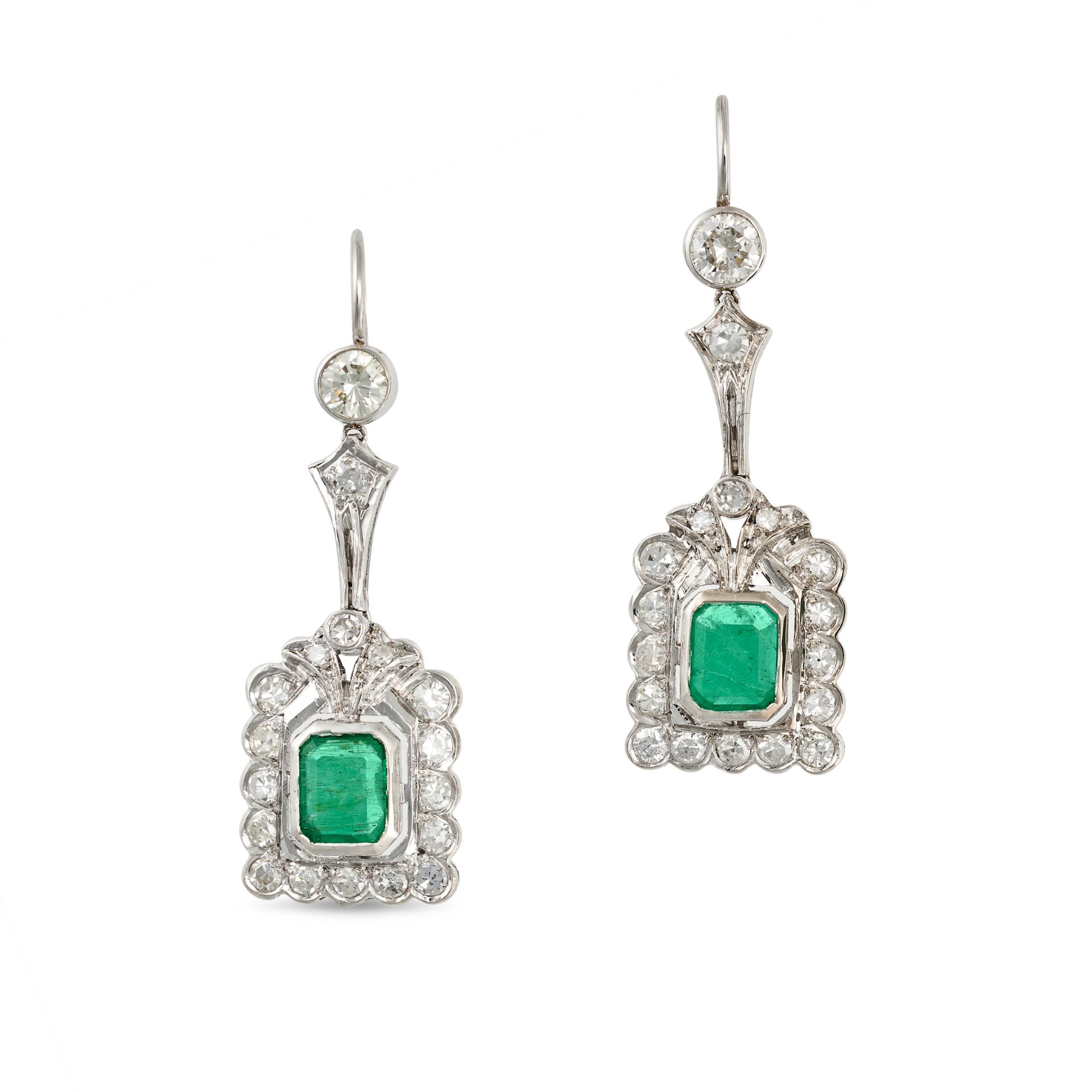 A PAIR OF EMERALD AND DIAMOND DROP EARRINGS in white gold, each set with an octagonal step cut em...