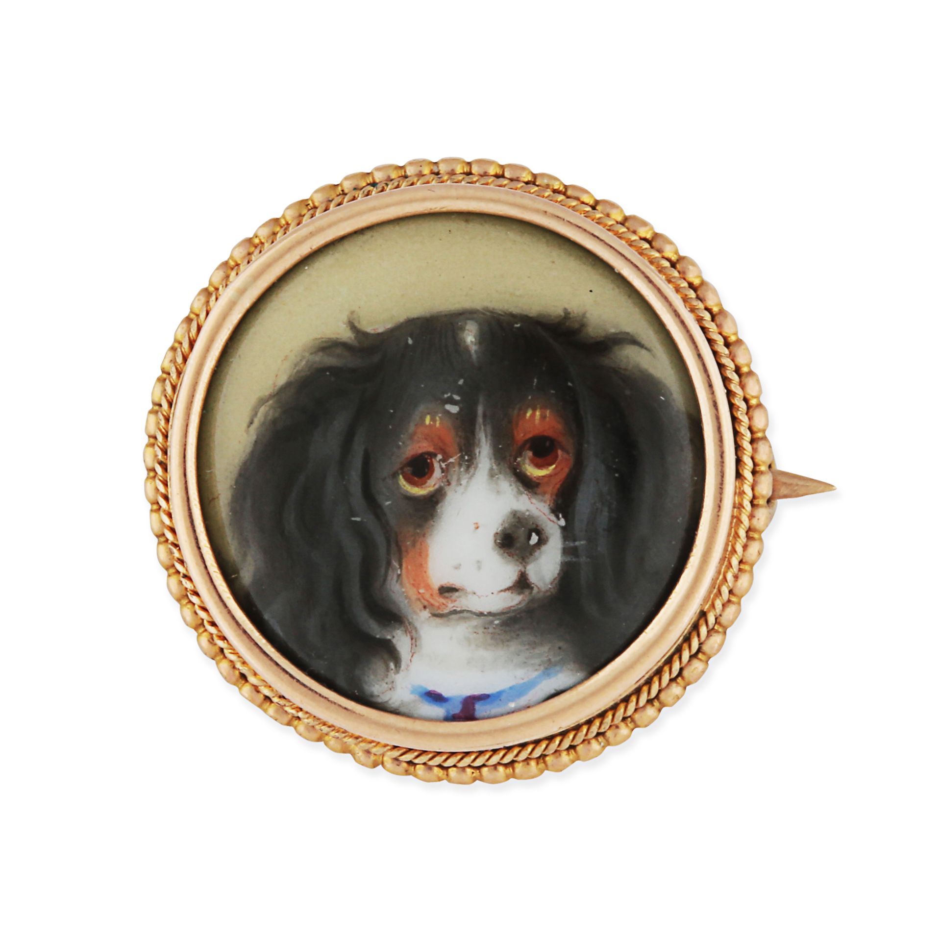 AN ANTIQUE KING CHARLES SPANIEL PAINTED MINIATURE DOG BROOCH in yellow gold, set with a circular ...