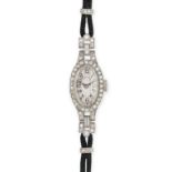 TIFFANY & CO., A VINTAGE DIAMOND WRISTWATCH in 18ct white gold, the oval dial set with a border o...
