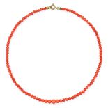 A CORAL BEAD NECKLACE comprising a single row of graduated polished coral beads, no assay marks, ...