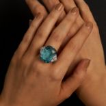 A FINE AQUAMARINE AND DIAMOND RING set with a cushion cut aquamarine of 22.43 carats, accented on...