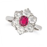 A RUBY AND DIAMOND CLUSTER RING in 18ct white gold, set to the centre with an oval cut ruby in a ...