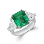 A FINE COLOMBIAN EMERALD AND DIAMOND RING in 18ct white gold, set with an octagonal step cut emer...