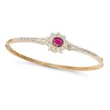 AN ANTIQUE RUBY AND DIAMOND BANGLE in yellow gold, the hinged body set with an oval cut ruby of a...