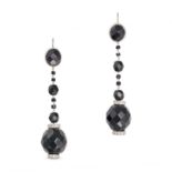 A PAIR OF ONYX AND DIAMOND DROP EARRINGS each set with a faceted onyx suspending a row of onyx be...