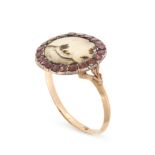 AN ANTIQUE DENDRITIC AGATE AND GARNET RING in yellow gold, set with an oval cabochon cut piece of...